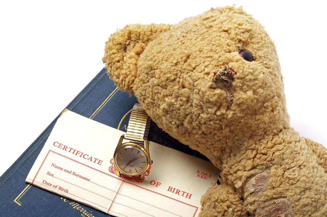 birth certificate alongwith wrist watch and a teddy bear
