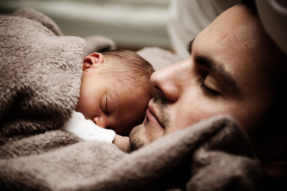 newborn baby asleep on father's chest